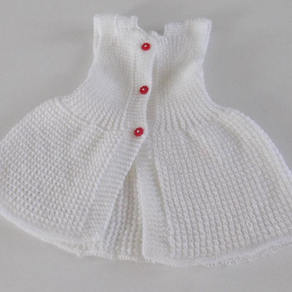 Robe pour bébé tricotée main , coloris blanc , boutons rouges forme fleur , taille 6 à 9 mois.