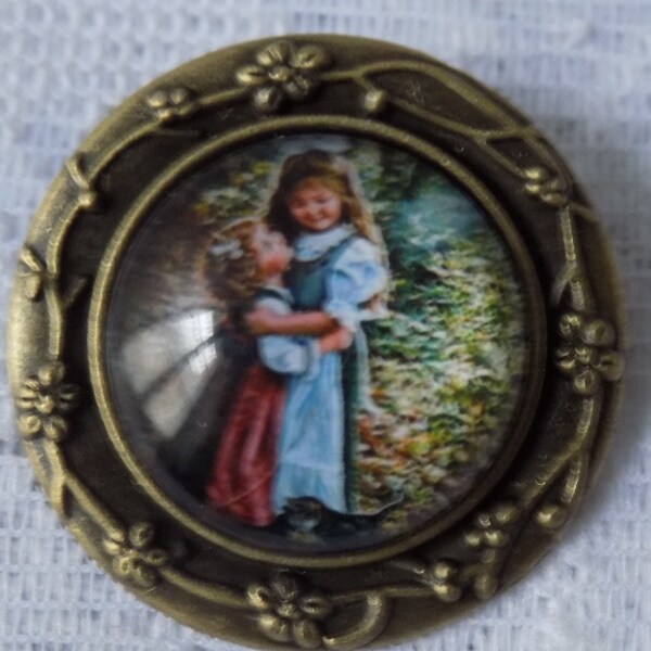 Broche ronde bronze,support décor fleurs ciselées,cabochon en verre,motif fillettes.