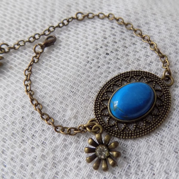 Bracelet bronze et bleu,connecteur ciselé ovale,cabochon howlite teintée,chaînettes,breloque fleur avec strass.