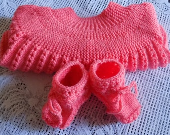 Ensemble brassière et chaussons pour bébé réalisé à la main au tricot , coloris corail , taille 6/9 mois.