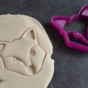 K&ouml;nnte beinhalten: Nahaufnahme eines wei&szlig;en Fuchs-Ausstechers und eines rosa Fuchs-Ausstechers. Der Ausstecher ist aus Kunststoff und hat ein detailliertes Design.