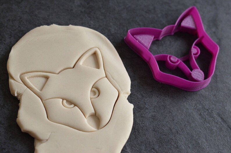 K&ouml;nnte beinhalten: Nahaufnahme eines wei&szlig;en Fuchs-Ausstechers und eines rosa Fuchs-Ausstechers. Der Ausstecher ist aus Kunststoff und hat ein detailliertes Design.