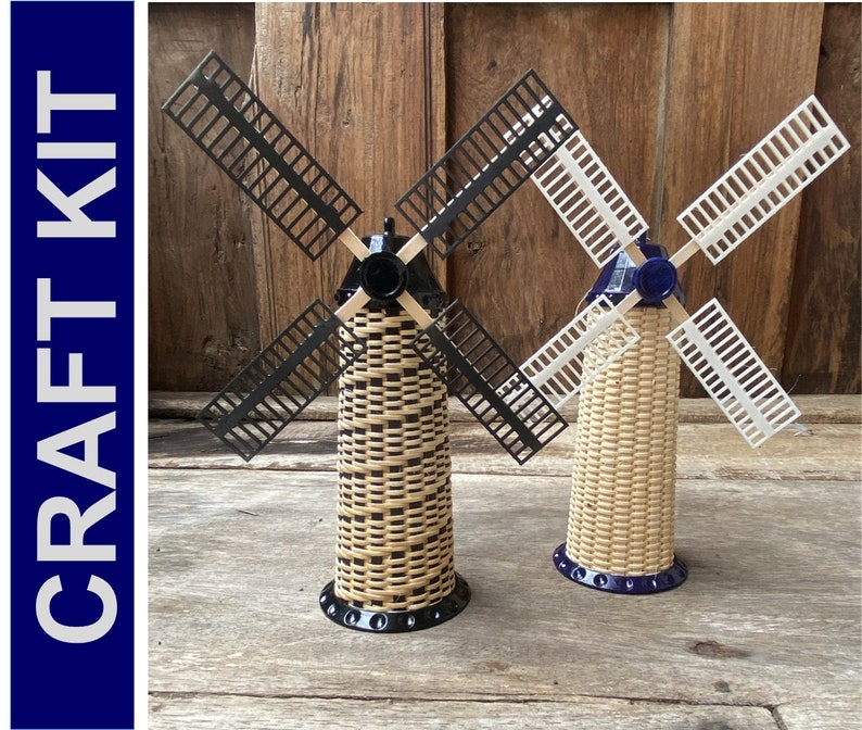 May include: Two miniature wooden windmills with black and white blades. The windmills are made of woven wood and have a blue base.