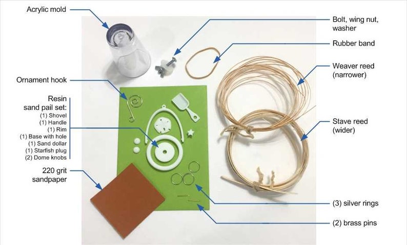 May include: A set of craft supplies for making a resin sand pail ornament. The set includes a clear plastic mold, a brown rubber band, a white resin sand pail set, a green sheet of paper with white resin pieces, a brown piece of sandpaper, two brown reeds, and three silver rings.