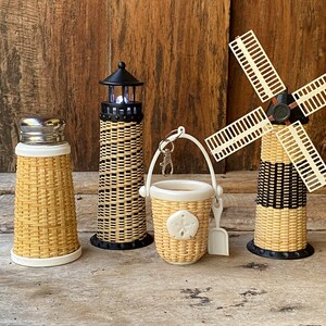 May include: Set of four woven wicker miniature lighthouse, windmill, bucket and shaker. The lighthouse and windmill have black and white stripes. The bucket has a sand dollar design.