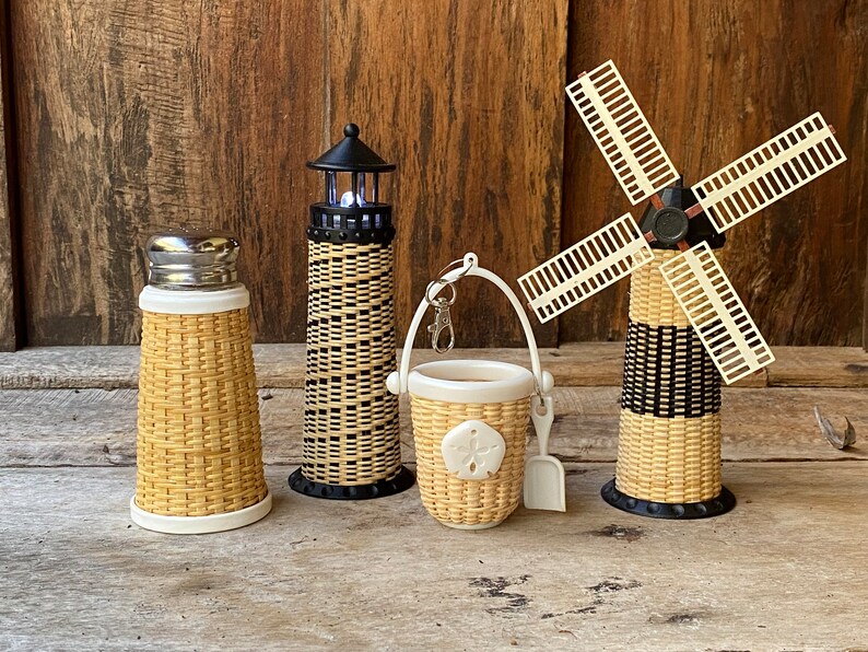 May include: Set of four woven wicker miniature lighthouse, windmill, bucket and shaker. The lighthouse and windmill have black and white stripes. The bucket has a sand dollar design.