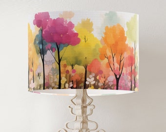 May include: A lampshade with a watercolor design of a forest with trees in shades of pink, yellow, orange, and green.
