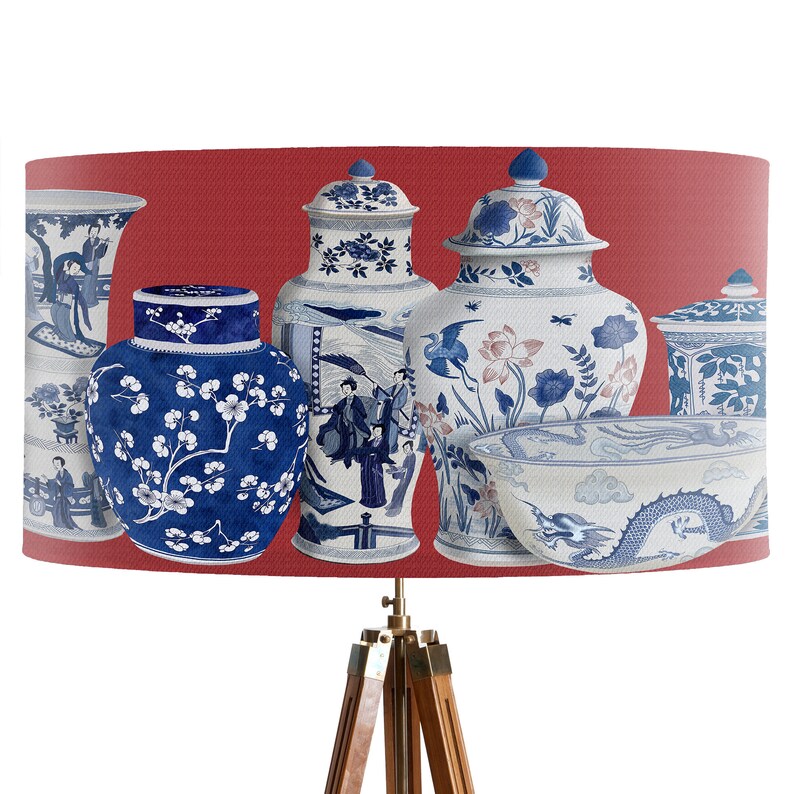 May include: A red lampshade with a design of blue and white porcelain vases and bowls. The vases have floral and geometric patterns.