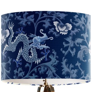 May include: A blue and white lampshade with a dragon and floral pattern. The dragon is in a light blue color and the floral pattern is in a darker blue color.