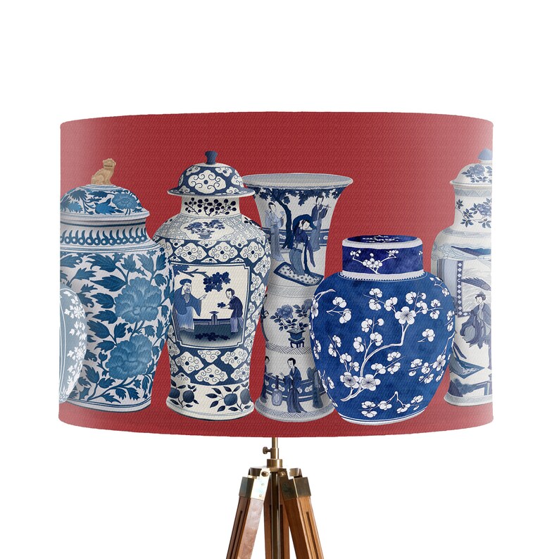 May include: Five blue and white porcelain vases with floral and figural designs on a red background. The vases are arranged in a row, with the largest vase in the center.