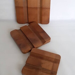 Puede incluir: Juego de cuatro posavasos de madera en tonos marrones. Los posavasos tienen un dise&ntilde;o acanalado y son cuadrados y rectangulares. Protegen las superficies de las marcas de bebidas.