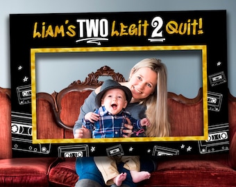Può includere: Una cornice rettangolare nera per cabina fotografica con la scritta dorata LIAM'S TWO LEGIT 2 QUIT! in alto. La cornice è decorata con disegni a linee bianche di cassette audio e stelle, e presenta un bordo dorato attorno all'apertura centrale.