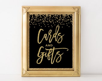 May include: Gold framed sign with black background and gold glitter confetti. The sign says "Cards and Gifts" in gold glitter lettering.
