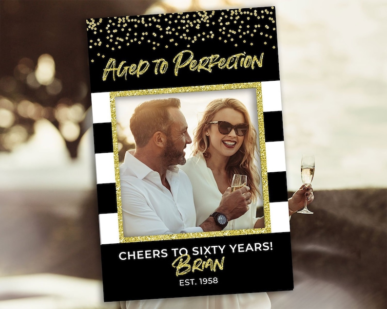 May include: Black and white photo booth prop with gold glitter accents. The prop features a photo frame with the text "Aged to Perfection" and "Cheers to Sixty Years! Brian Est. 1958".