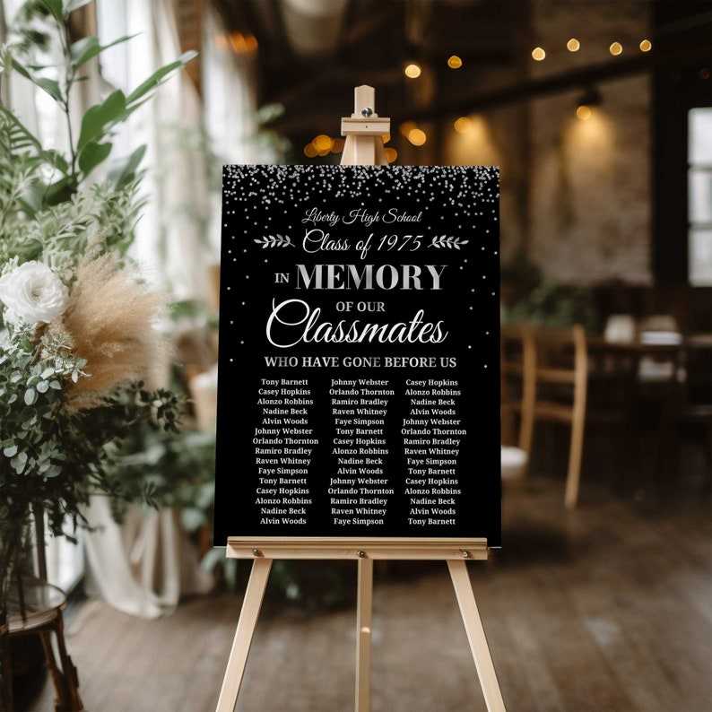 May include: Black and white sign with a silver glitter background. The sign reads "Liberty High School Class of 1975 In Memory of Our Classmates Who Have Gone Before Us" and lists the names of classmates.