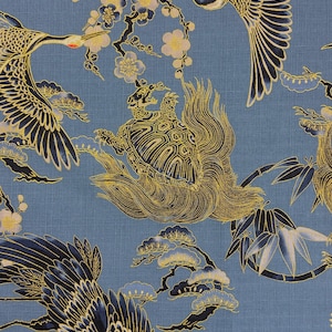 Op de afbeelding: Blauwe stof met een Japans geïnspireerd ontwerp. Het toont kranen met zwarte en marineblauwe vleugels en rode accenten, schildpadden en bloemmotieven. Gouden en witte details benadrukken de bloemtakken en schildpaddenschilden.