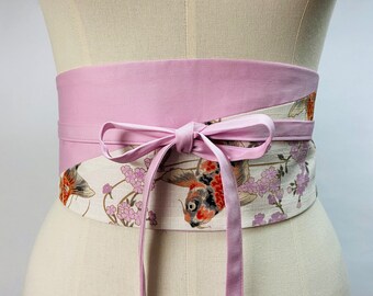 Reversible and adjustable two-tone Obi belt in Japanese printed cotton with Carp/Koi and Sakura motifs on a white background and plain pink, high waist.