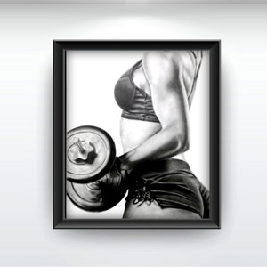 May include: Black and white drawing of a person lifting a dumbbell. The person is wearing a sports bra and shorts. The drawing is framed in a black frame.