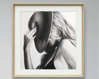 May include: Black and white drawing of a woman with long hair wearing a black hat. The woman is looking down and her hand is holding the brim of the hat.