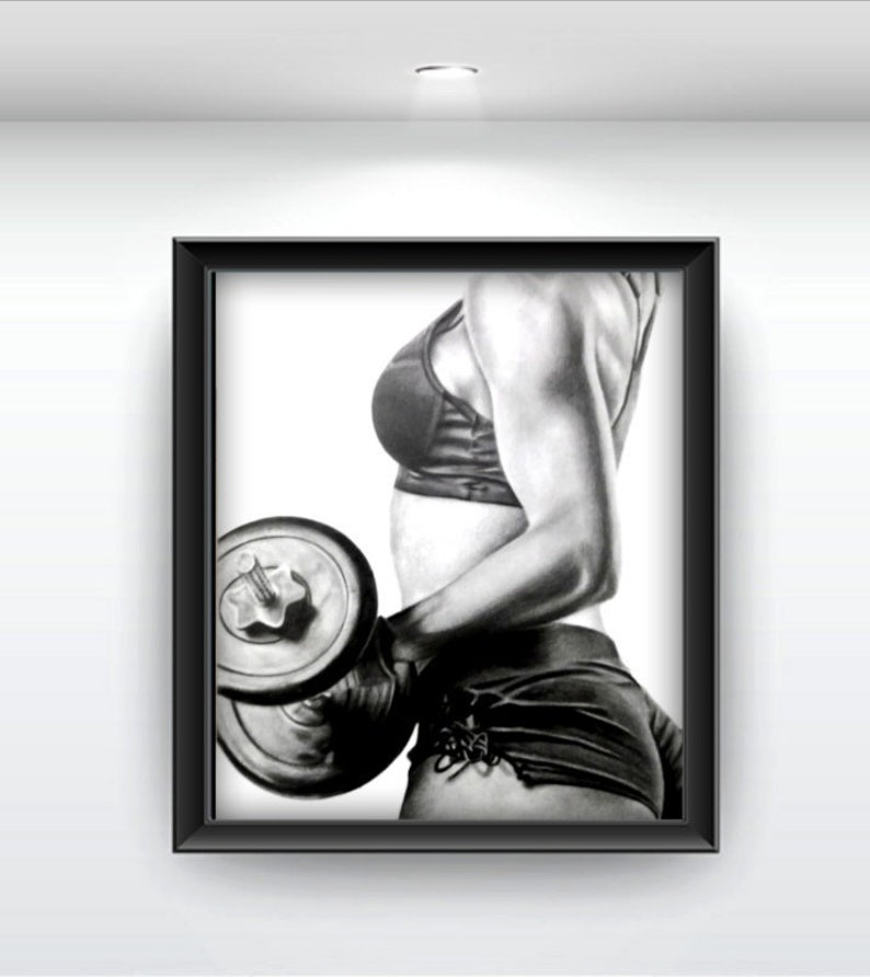 May include: Black and white drawing of a person lifting a dumbbell. The person is wearing a sports bra and shorts. The drawing is framed in a black frame.