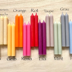 Könnte beinhalten: Ein Set mit 10 Paaren kleiner Kerzen in verschiedenen Farben, darunter Weiß, Gelb, Orange, Rosa, Rot, Lila, Grau, Hellblau, Grün und Beige. Die Kerzen sind mit ihren Farben in Deutsch beschriftet: Weiß, Gelb, Orange, Rosa, Rot, Lila, Grau, Hellblau, Mint und Taupe.