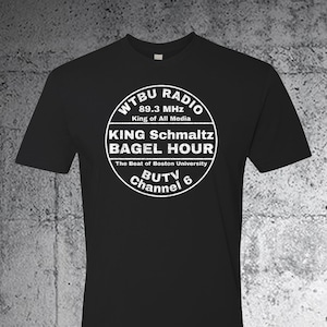 Puede incluir: Camiseta negra con un gráfico circular blanco que dice "WTBU RADIO 89.3 MHz King of All Media KING Schmaltz BAGEL HOUR The Beat of Boston University BUTV Channel 6"