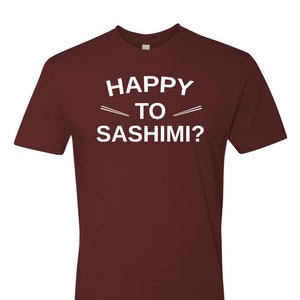 May include: Burgundy t-shirt with white text that reads "Happy to Sashimi?" with two white lines representing chopsticks above the word "to".