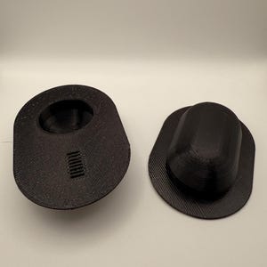 May include: Two black 3D printed plastic molds, one with a round opening and the other with a rectangular opening.