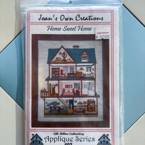 Op de afbeelding: Een Joan's Own Creations Home Sweet Home zijden lint borduurwerk applique series 402 set in een doorzichtige plastic zak. De hoes bevat een illustratie van een poppenhuis met meerdere verdiepingen, kamers en meubels.