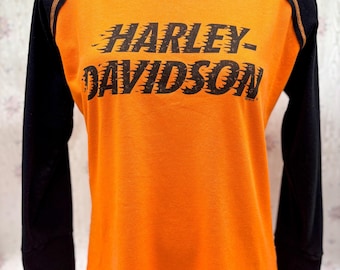 Camiseta de manga larga raglán naranja y negra para mujer de Harley-Davidson – Northwoods Harley-Davidson Arbor Vitae, WI (2018)