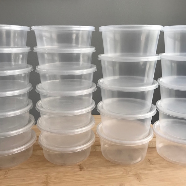 May include: A stack of clear plastic containers, stacked in two rows of eight. The containers are all the same size and shape, and they are all empty.