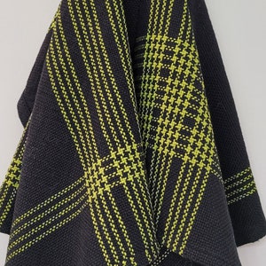 Könnte beinhalten: Schwarzes Küchentuch mit einem grün-schwarzen Karomuster.