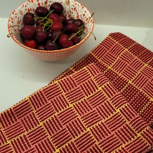 May include: A set of three red and yellow kitchen towels with a woven checkered pattern.