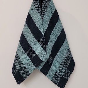 May include: A black and green striped kitchen towel hanging on a hook.