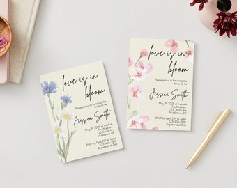 以下が含まれることがあります： ピンクの花と青と白の花の水彩画が描かれた、ラブイズインブルームと書いてある、ジェシカ・スミスという名前の結婚式の招待状が2枚あります。