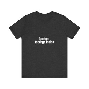 Camiseta con el mensaje "Precaución y sentimientos" (Cautive Feelings Inside): Camiseta gráfica minimalista. imagen 2