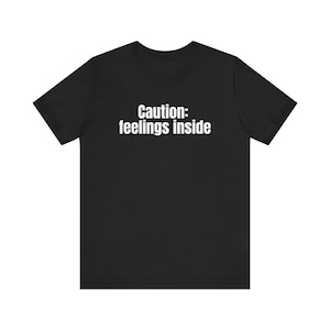 Camiseta con el mensaje "Precaución y sentimientos" (Cautive Feelings Inside): Camiseta gráfica minimalista. imagen 1