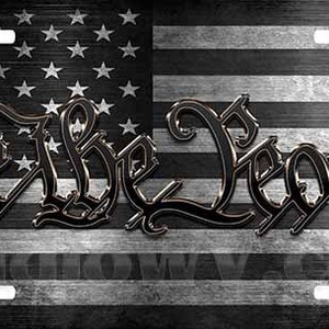 May include: A black and white American flag with the words "We the People" in a stylized font. The flag is distressed and has a wood grain texture.