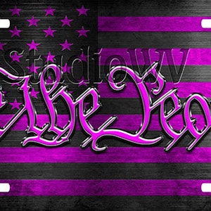 May include: A black and purple American flag with the words "We the People" in a stylized font.