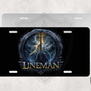 May include: Black and gold metal license plate with a dark image of a lineman standing on a power pole with lightning bolts in the background. The text "LINEMAN" is in gold letters.