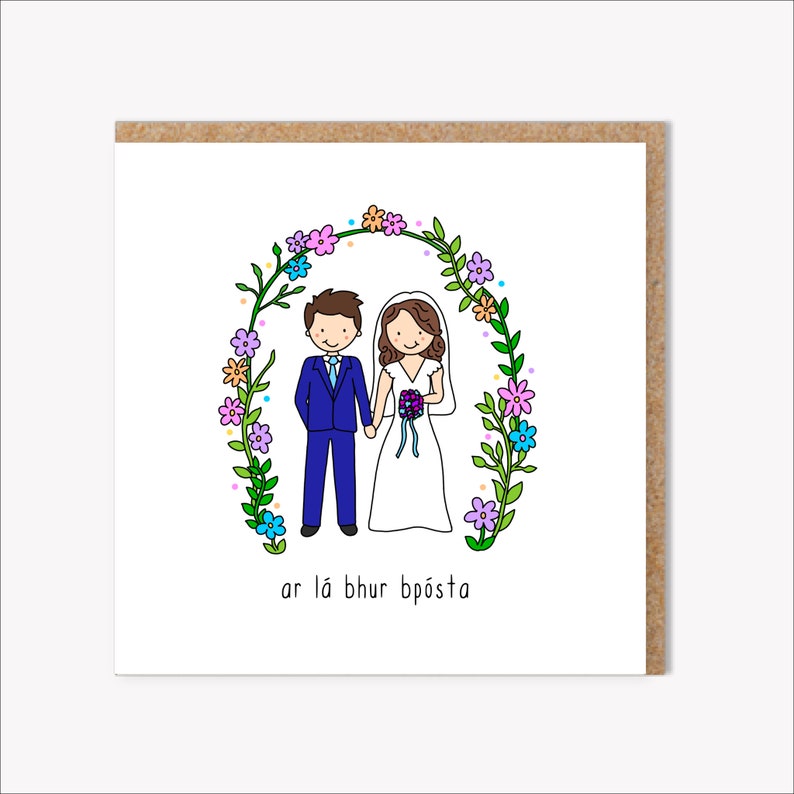 K&ouml;nnte beinhalten: Eine Hochzeitskarte mit einer Cartoon-Illustration eines Brautpaares, das unter einem Blumenbogen steht. Der Text auf der Karte lautet "ar la bhur bp&oacute;sta".