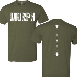 May include: A green t-shirt with white text that reads "MURPH" and includes the workout details: "1 mile run, 100 pull ups, 200 push ups, 300 air squats, 1 mile run". The back of the shirt has white text that reads "TENTWENTY" with a kettlebell icon.