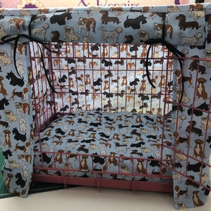 Peut inclure: Une housse de cage pour chien en tissu imprimé de chiens bleus et blancs avec un ruban noir. La housse a un rabat supérieur qui peut être rabattu pour créer une zone ombragée pour le chien.