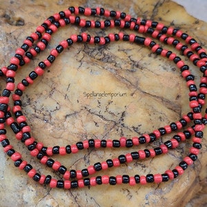 May include: A double strand necklace made of black and red beads. The beads are small and round, and the necklace is about 40 inches long.