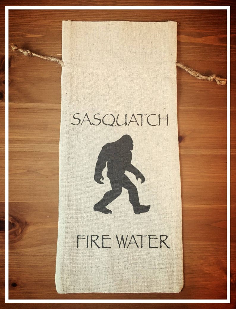 May include: A beige fabric bag with a black silhouette of a Sasquatch and the text "Sasquatch Fire Water".