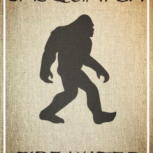 May include: A brown burlap background with the text "Sasquatch Fire Water" in black lettering. A black silhouette of a Sasquatch walking to the right is in the center of the image.