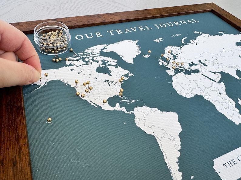 Custom world push pin map.  Dark teal background with gold push pins