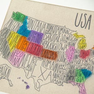 May include: A hand-drawn map of the United States with each state outlined in a different color. The states are labeled with their names in a handwritten font. The map is on a beige canvas background.