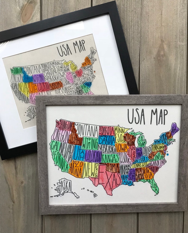 May include: Two framed prints of a hand-drawn map of the United States. The map is outlined in black and each state is filled in with a different color. The text "USA MAP" is written in black at the top of each print.