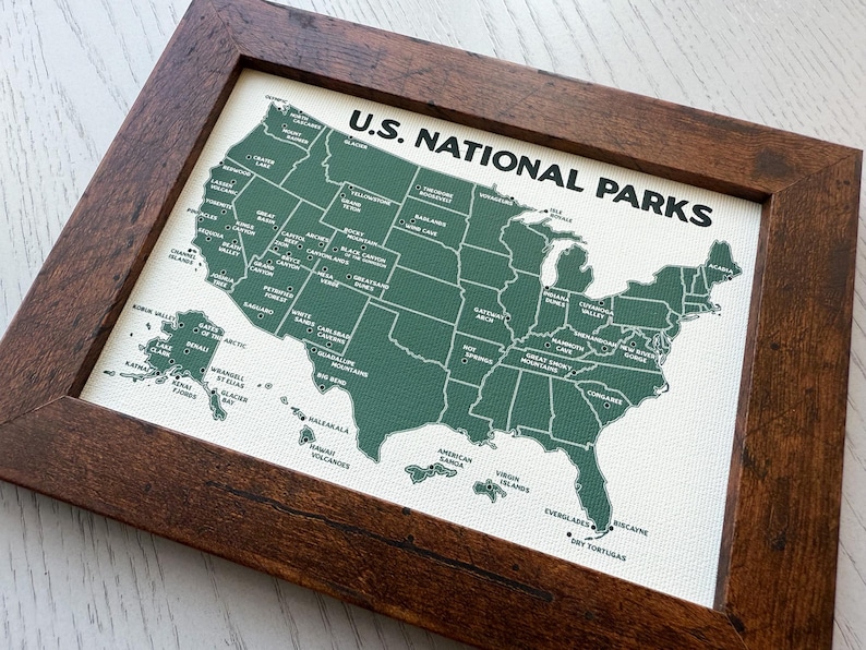 Pu&ograve; includere: Una mappa incorniciata degli Stati Uniti, che evidenzia i parchi nazionali in verde su uno sfondo bianco. La mappa &egrave; etichettata "U.S. NATIONAL PARKS" in testo nero ed &egrave; racchiusa in una cornice di legno marrone scuro.